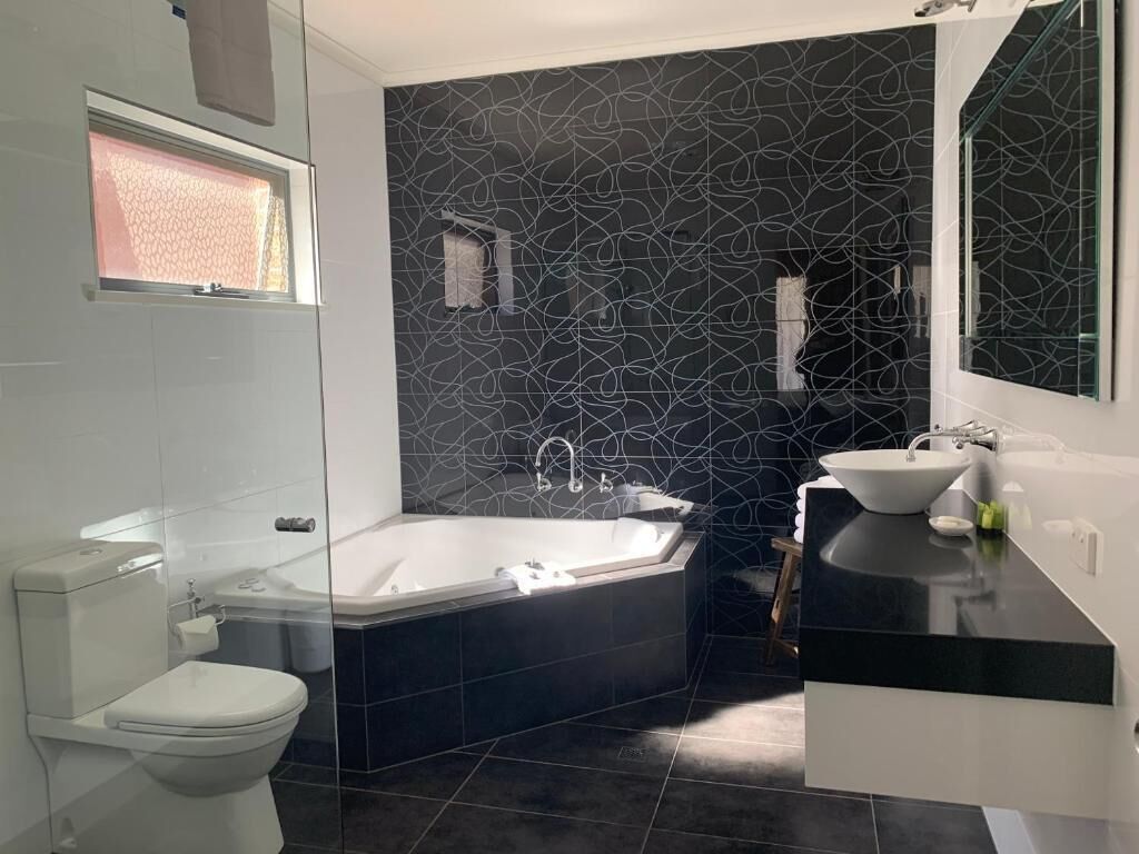 Une salle de bain moderne avec une baignoire, des toilettes et un lavabo.