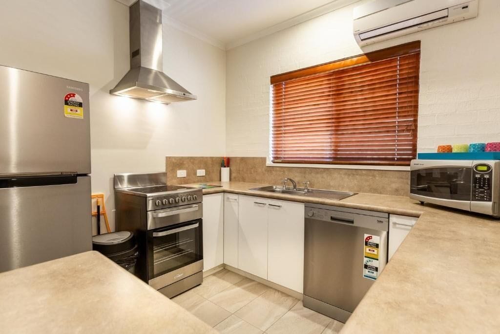A modern kitchen with stainless steel appliances, a built-in oven, a dishwasher, and a microwave.