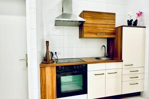 Een oven, een kookplaat, een waterkoker, kookgerei, borden en bestek
