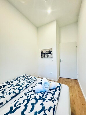A bedroom with a bed, a white door, and a wall-mounted picture. - Private Room; Just 11 Min Walk to Atzgersdorf Park (Wien)