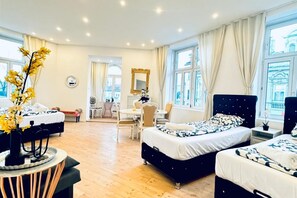Une chambre d’hôtel avec deux lits, un bureau et une chaise.
