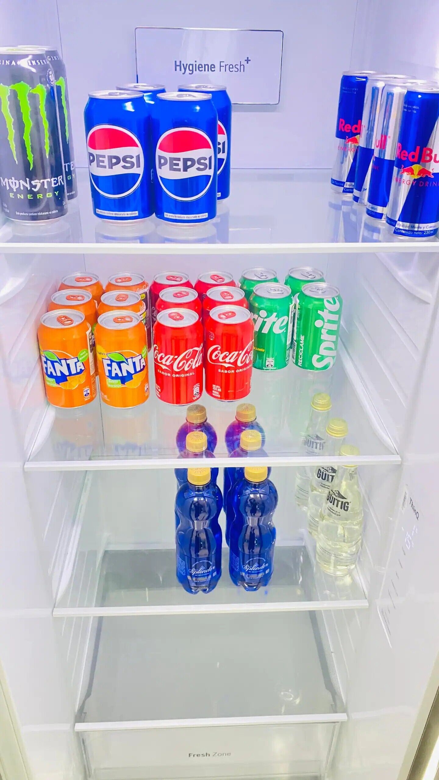 Un refrigerador lleno de diversas bebidas, incluyendo Fanta, Coca-Cola, Sprite, Pepsi, Red Bull y GÜTTIG.