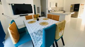 A modern kitchen with white countertops, a built-in oven, and a stainless steel refrigerator.