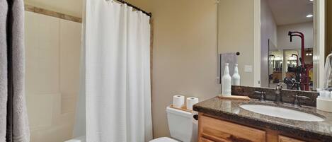 A bathroom with a bathtub, toilet, and sink.