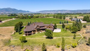 A large, two-story house with a spacious front yard and a driveway. - Rustic 8B Estate on 40 acres – 9,900sqft Estate on Private Ranch with 2 Hot Tubs (Heber City)