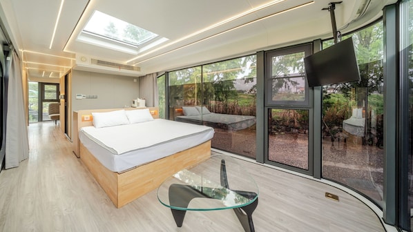 A modern bedroom with a large bed, a glass table, and a TV. - Gyeongju Orion Caravan (Gyeongju)