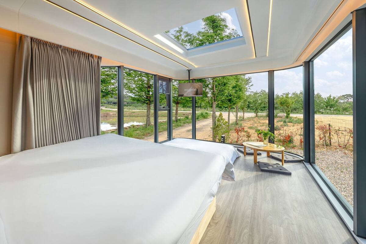 Un dormitorio moderno con una cama grande, un tragaluz y vistas al exterior.