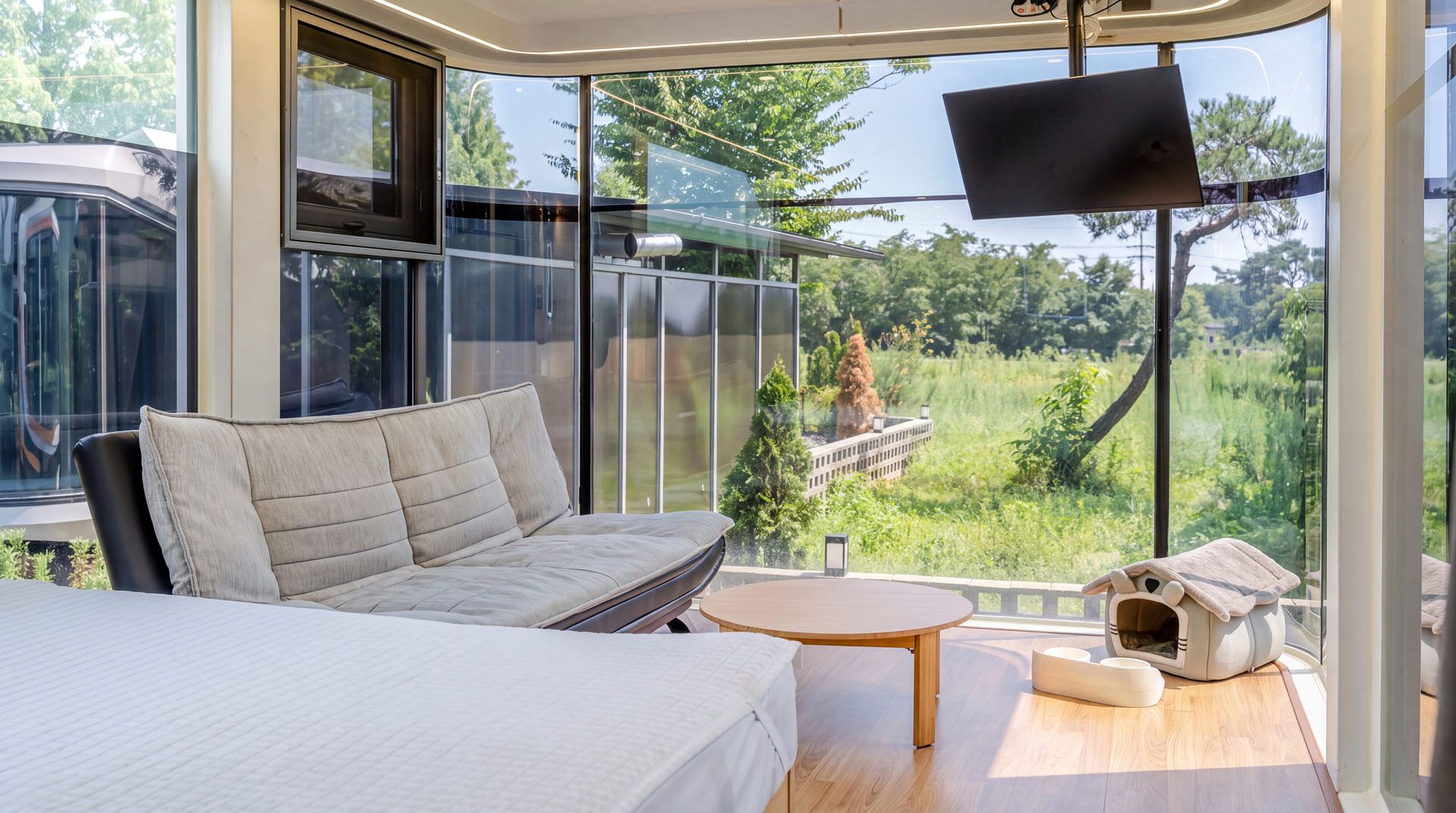 Un dormitorio moderno con un sofá, una cama, una mesa redonda y una casita para mascotas.