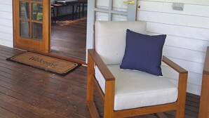 A wooden porch with a wooden chair and a doormat. - Country Cottage with Valley Views, 15mins to Canungra, 30mins to Mt Tamborine (Illinbah)