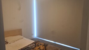 Una camera da letto con un letto, una testiera e un lampadario a parete.
