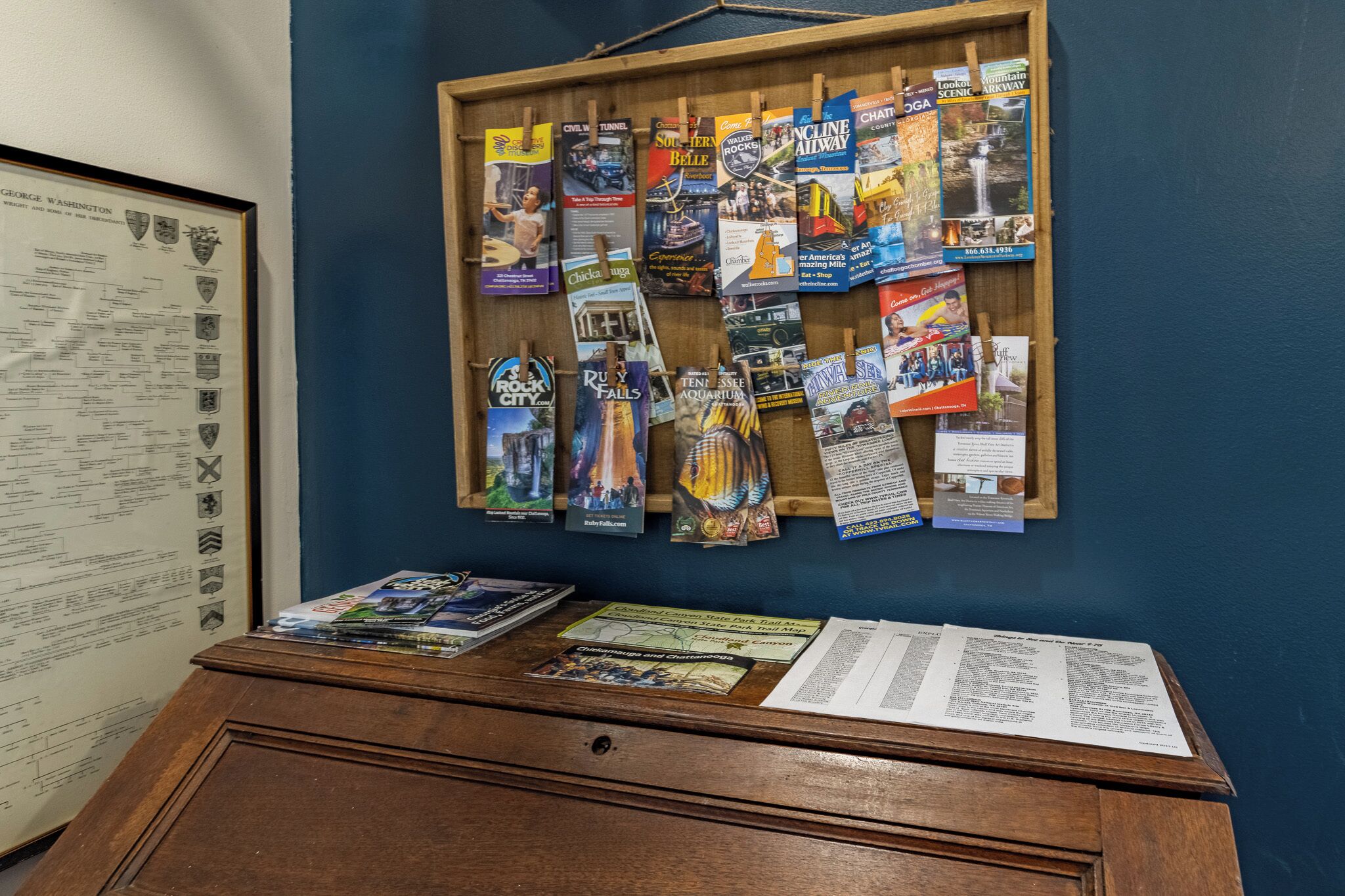 A bulletin board with travel brochures and a framed map.