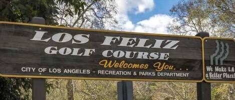 Letrero del campo de golf Los Feliz, dando la bienvenida a visitantes y mencionando al Departamento de Recreación y Parques de la Ciudad de Los Ángeles.