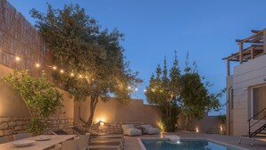 Un espace aménagé au bord de la piscine, comprenant une table à manger, des chaises et des fauteuils confortables.