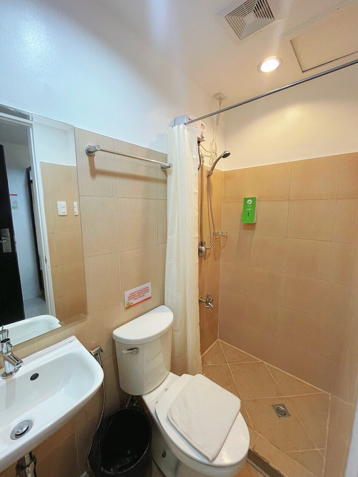 A bathroom with a sink, toilet, shower, and a towel rack.