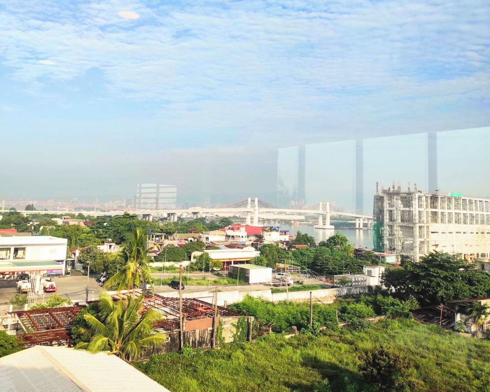 A cityscape with a bridge, buildings, and greenery.