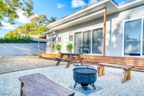 A modern house with a covered patio, a barbecue grill, and outdoor seating. - Bellbird Hideaway (Bellbird Heights)
