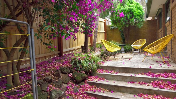 A staircase with pink flower petals, a wooden fence, and yellow chairs. - Beautiful lakeside unit, walk to train station, schools and Eastland (Ringwood East)