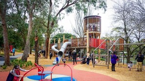 A playground with slides, swings, and climbing structures surrounded by trees. - Beautiful lakeside unit, walk to train station, schools and Eastland (Ringwood East)