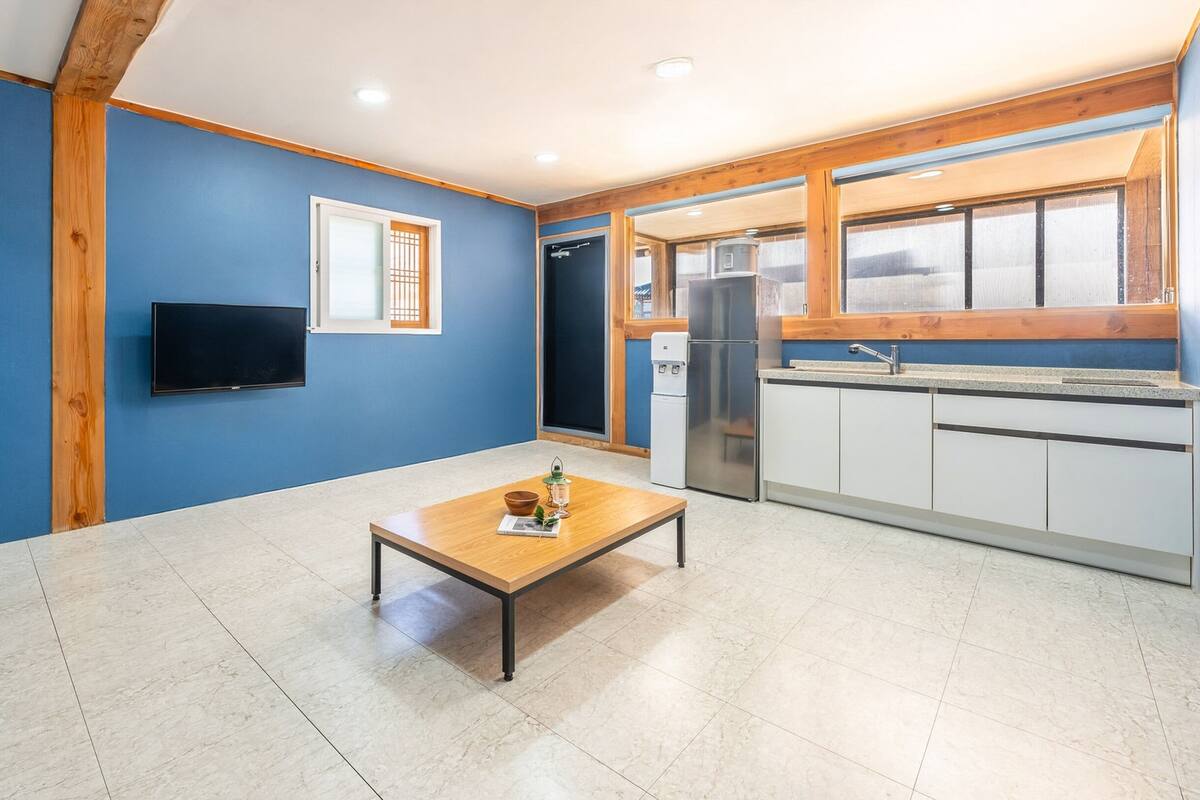 Eine moderne Küche mit einem eingebauten Kühlschrank, einer Spüle und einem Fenster, das auf den Raum blickt.
