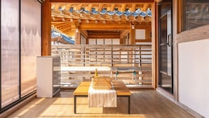 A traditional Japanese room with tatami flooring, a low wooden table, and a sliding door leading to a view of traditional architecture. - Gyeongju Aratteul Hanok Pet Pension (Gyeongju)