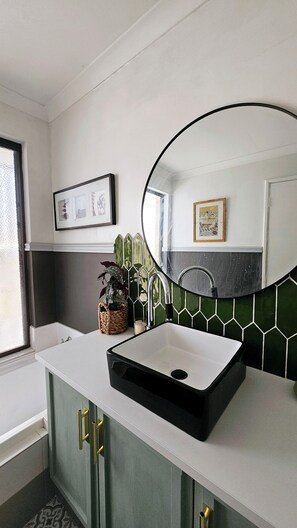A bathroom with a white countertop, a black sink, green cabinets, a large mirror, and a tiled backsplash. - Joyful Living 
A private space all to yourself, complete with a beautiful pool 
 (Beeliar)