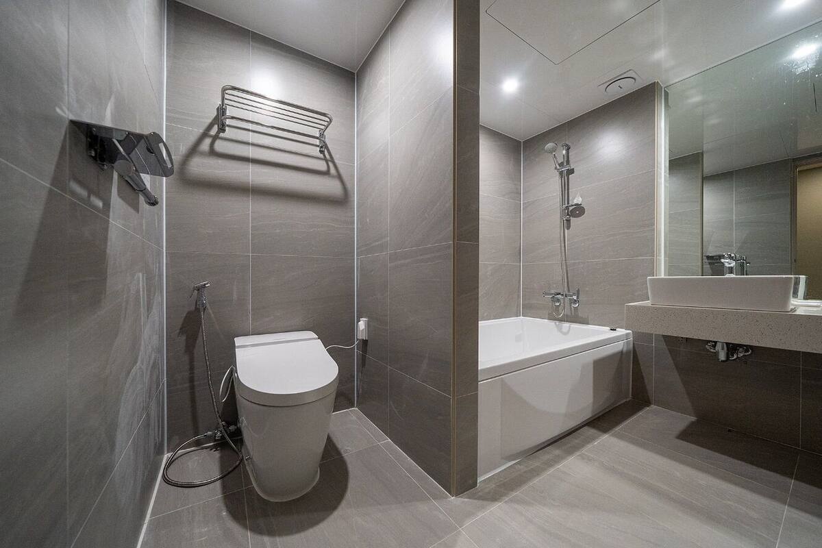 Une salle de bain moderne équipée de toilettes, d’un bidet et d’une baignoire.