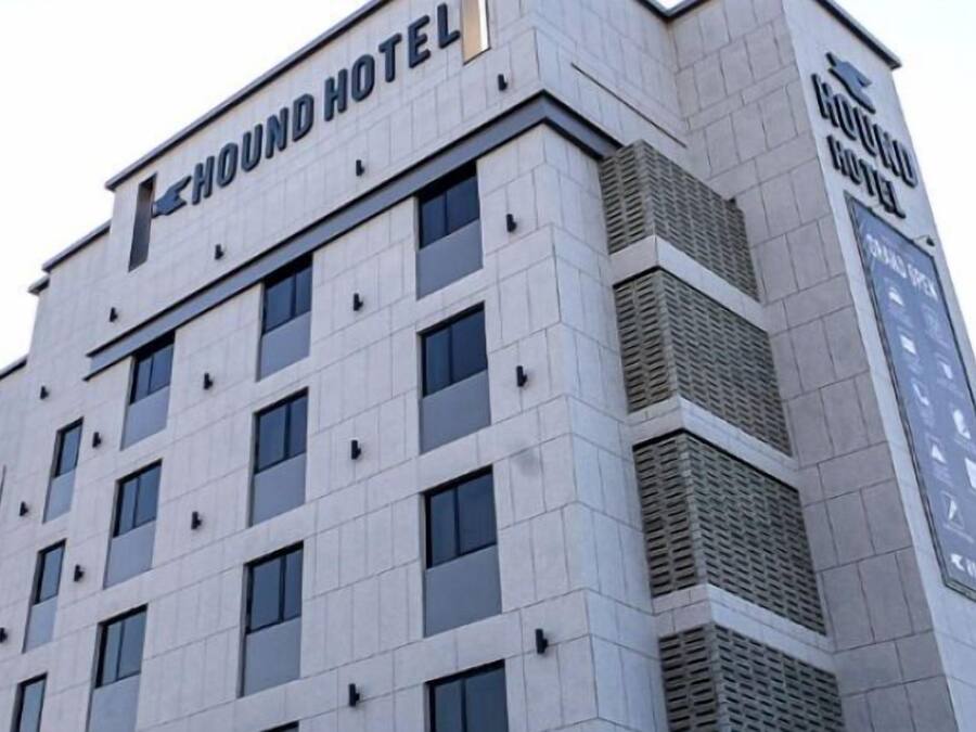 A modern building with a sign reading "HOUND HOTEL".