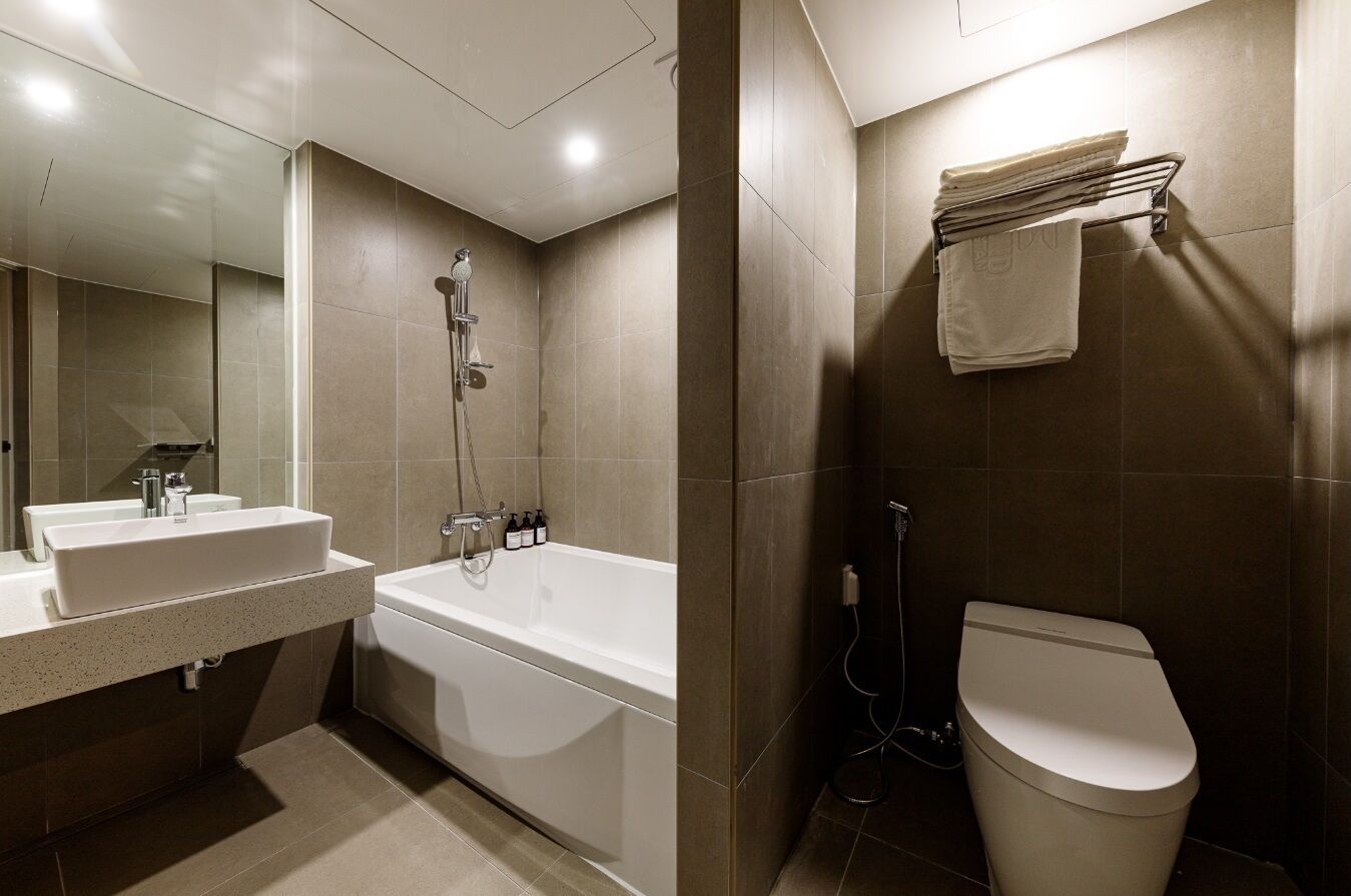 A modern bathroom with a bathtub, toilet, and sink.