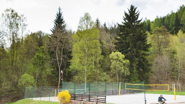 Une piste cyclable avec une zone délimitée par un filet et un banc.