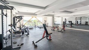 A spacious gym with various exercise equipment, large windows, and a high ceiling. - Rent a home away from home in front of the Best View of beautiful Samaná Bay! (Samana)