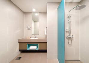 A modern bathroom with a sink, mirror, and shower.