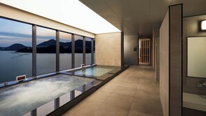A modern hotel corridor with a glass railing overlooking a body of water and mountains. - YEOSU BELLE MER (Yeosu)