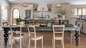 A modern kitchen with a central island, pendant lighting, and wooden chairs. - Luxury Healdsburg Retreat. Pool, Sauna, Hot Tub, Near Plaza, Tesla charger (Healdsburg)