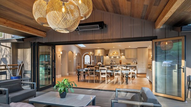 A modern open-plan living area with a dining space, kitchen, and sliding glass doors leading to a balcony. - Luxury Healdsburg Retreat. Pool, Sauna, Hot Tub, Near Plaza, Tesla charger (Healdsburg)