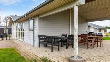 Relax in the covered patio area with comfortable seating and dining options.