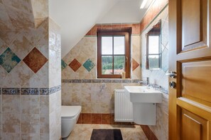 Un bagno con il water, un lavandino e una finestra.