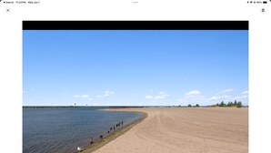 A beach with a sandy shore and a calm sea.