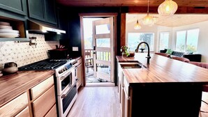 Une cuisine moderne avec des meubles en bois, un grand îlot central et une vue sur l’extérieur.