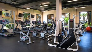 Ein Fitnessstudio mit Laufbändern, Crosstrainern und Gewichten.