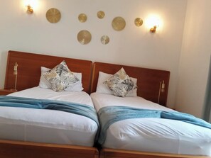 Ein Doppelbett mit Holz Kopfteil, zwei Kissen und einer blauen Decke.