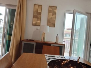 Ein Zimmer mit einem Bett, einem Schreibtisch, einer Lampe und einem Fenster mit Vorhängen.