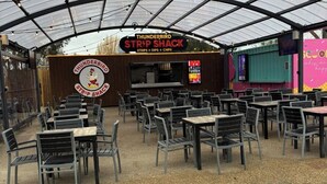 Un établissement Thunderbird Strip Shack doté d’une terrasse et d’un espace couvert.