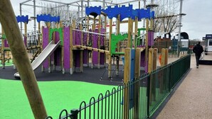 Une aire de jeux avec des structures d’escalade et un toboggan.
