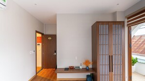 Un interior moderno con un banco de madera, una mesita con objetos decorativos y un gran armario de madera.