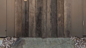 Une porte en bois avec un pommeau de douche et un tuyau.