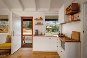 Eine moderne Küche mit weißen Schränken, Holz Arbeitsplatten und einer integrierten Kaffeemaschine.