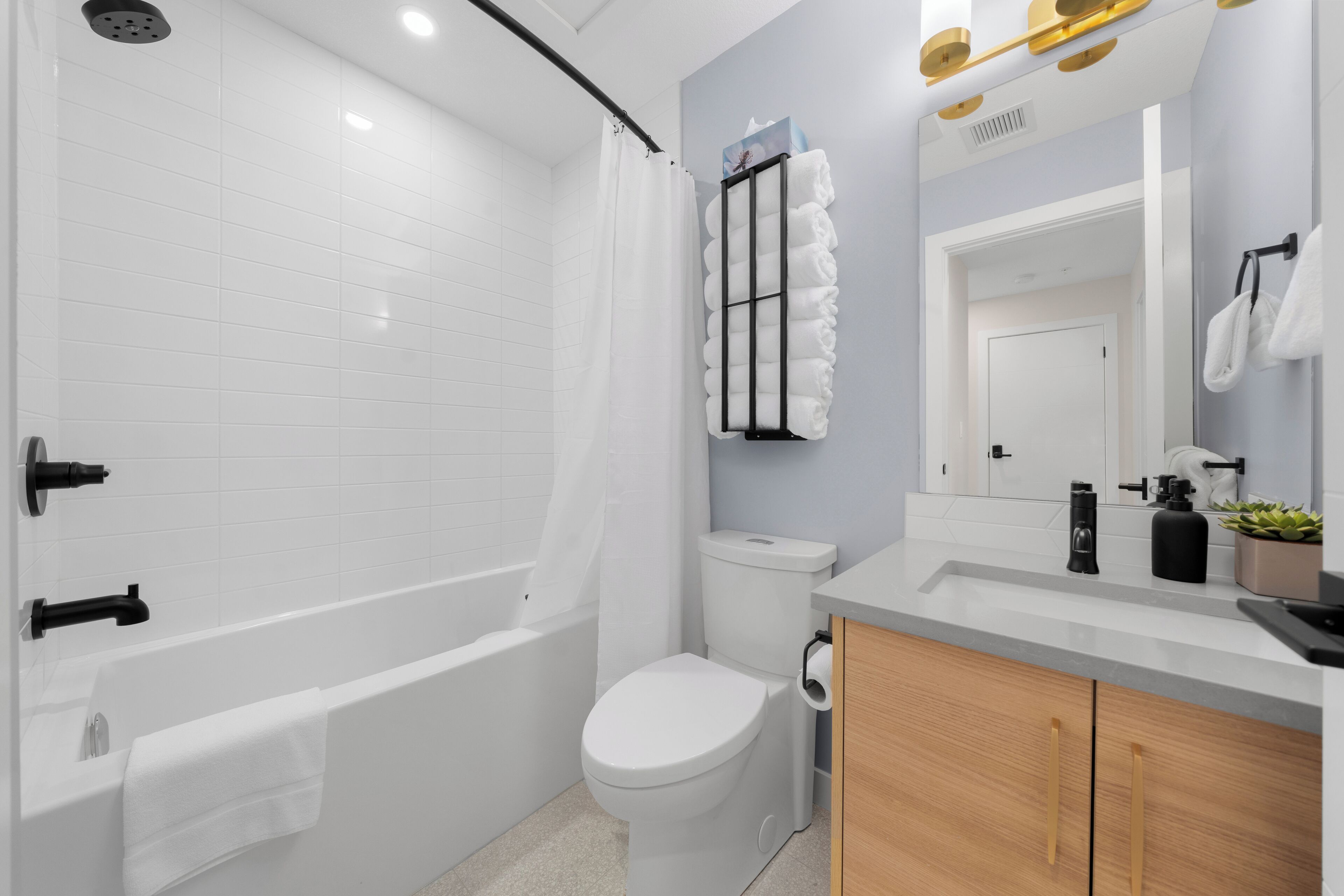 Une salle de bain moderne équipée d’une baignoire, de toilettes et d’un lavabo.