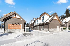 A modern hotel with a sign reading "SKYRIDGE 750 HARVIE HEIGHTS RD." It features a symmetrical facade with multiple windows and a flat roof. - Luxuriously Cozy 3-bedroom Townhouse in Harvey Heights - 2 min to Banff Gate (Harvie Heights)