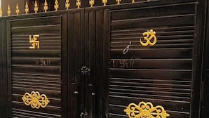 Schwarze Metalltüren mit goldenen Symbolen und Griffen.