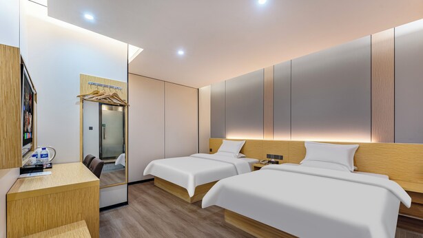 A modern hotel room with two beds, a wooden desk, a mirror, and a wardrobe. - Guangzhou Kaiyue Hotel Luoxi Subway Station Branch - Free Deliver Service to Canton Fair Complex During Canton Fair Period (Guangzhou)